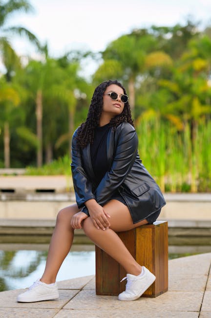 Woman wearing leather jacket and sunglasses in a garden setting