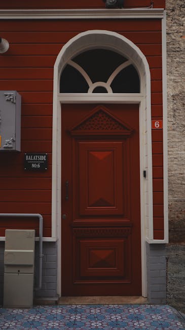 Traditional red door with an arched window and white trim